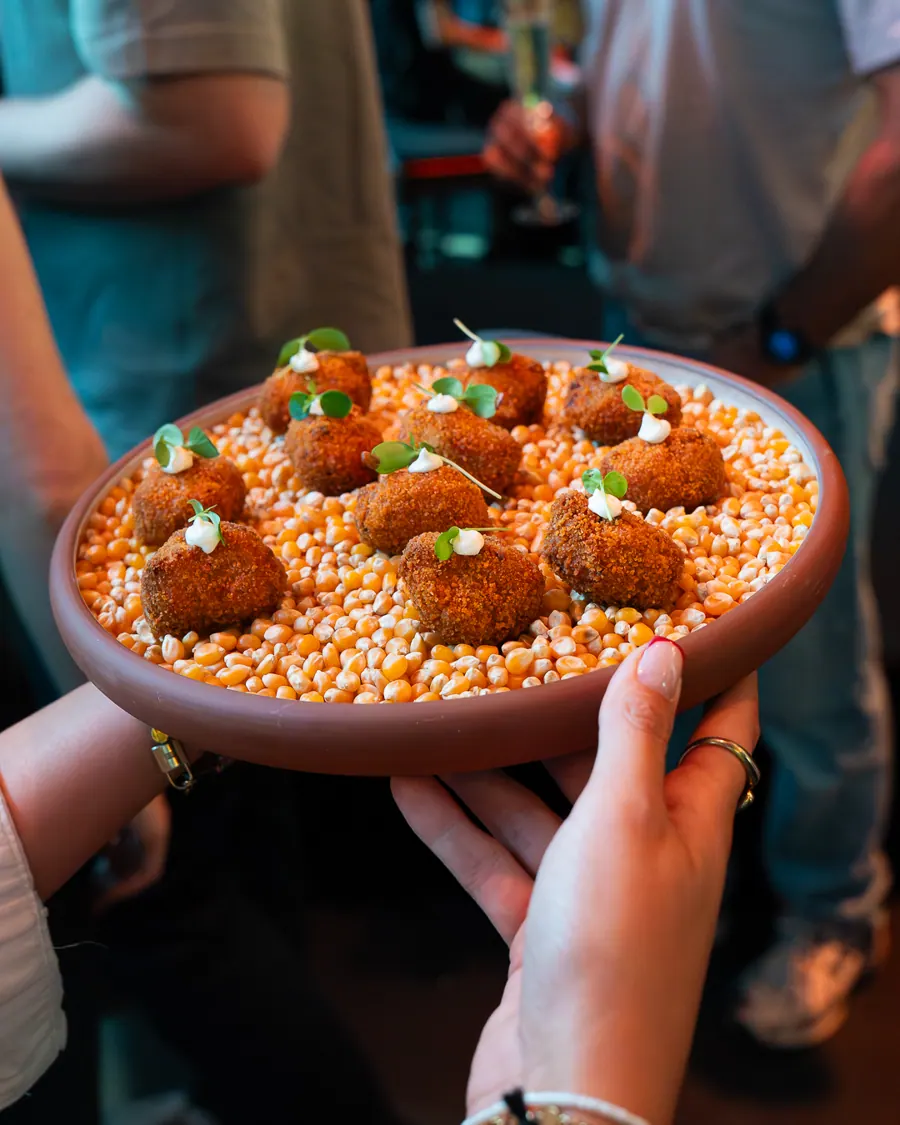 Kroketjes met toef op een schaal maïskorrels, doorgegeven op een receptie